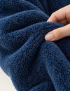 Main montrant la texture pelucheuse bleue du Kloody Pilou Pilou