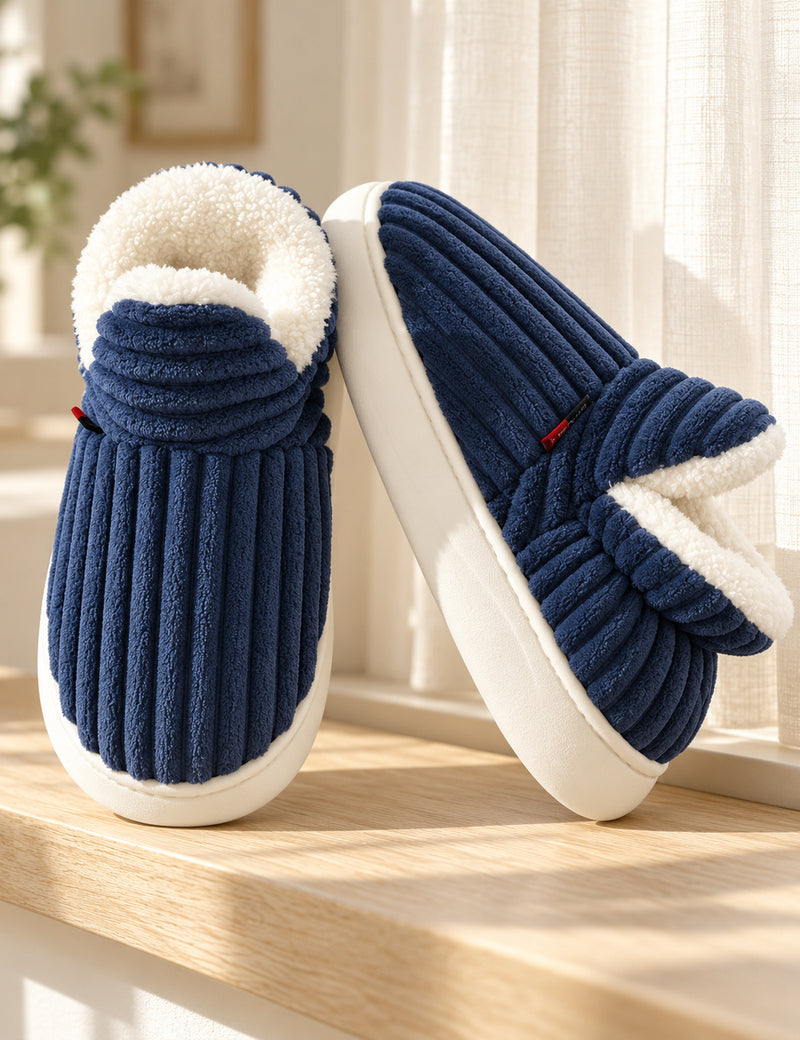 Chaussons Alix bleu marine vus de face et de côté sur un rebord en bois clair