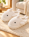 Chaussons Pilou Pilou Animal Marin, coloris blanc : paire sur un tapis ivoire près du canapé