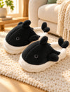 Chaussons Pilou Pilou Animal Marin, coloris noir : paire sur un tapis ivoire près du canapé