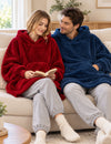Couple en Kloody Pilou Pilou rouge et bleu sur un canapé pendant une pause lecture